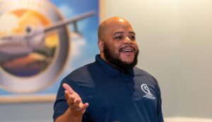 Man smiling while giving a speech at an Able Trust event.