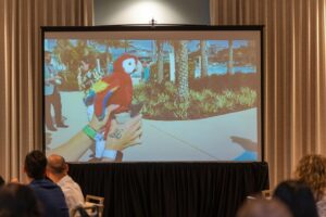 Projector screen image of a parrot at an Able Trust event.