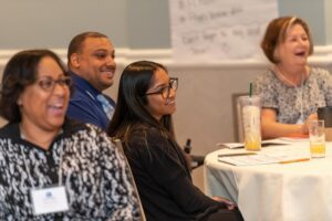 Group of people smiling at a table at one of the Able Trust events.